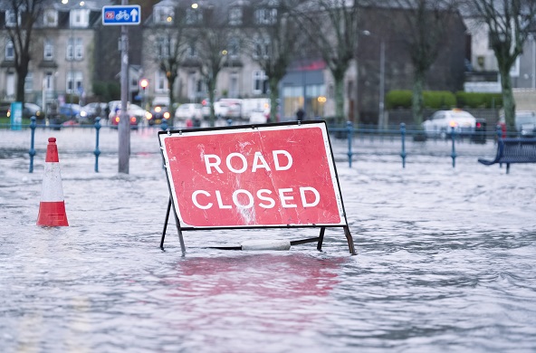 Photo of a road closed sign in flood water